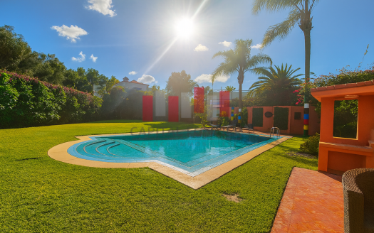 piscine ensoleillée entourée de jardin dans villa Oasis Casablanca