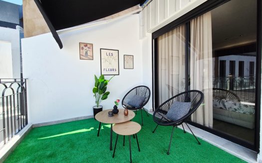 Terrasse meublée de 15m² avec salon de jardin noir, gazon synthétique, store banne et décorations murales, appartement neuf jamais habité Gauthier Casablanca
